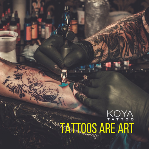  tattoo artist working on a client